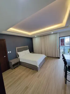 a large bedroom with a bed and a window at Hotel Cayuga in Puntarenas