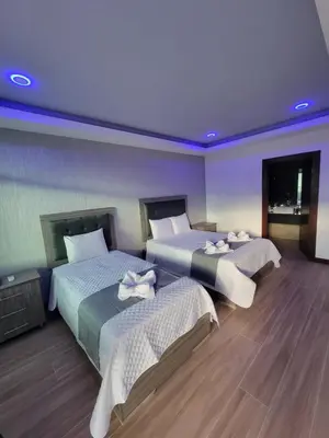 a hotel room with two beds and a purple ceiling at Hotel Cayuga in Puntarenas