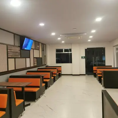 a waiting room with wooden tables and chairs at Hotel Cayuga in Puntarenas