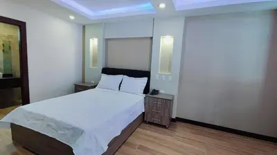 a bedroom with a large bed with white sheets at Hotel Cayuga in Puntarenas