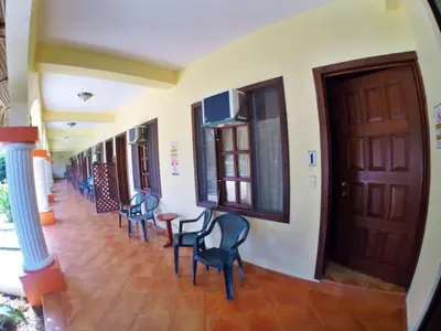 a hallway with chairs and a table in a building at Hotel Esperanza in Carrillo