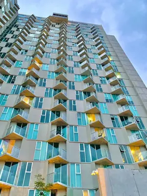 a tall apartment building with blue windows at Único Apartamento en Nuevo y Moderno Condominio in San José