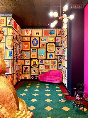 a room with a bed in a room with paintings on the wall at Único Apartamento en Nuevo y Moderno Condominio in San José