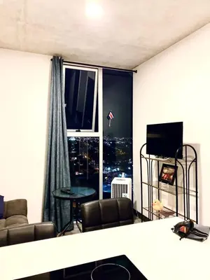 a living room with a view of a city at Único Apartamento en Nuevo y Moderno Condominio in San José