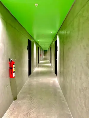 a hallway with a green ceiling and a fire extinguisher at Único Apartamento en Nuevo y Moderno Condominio in San José