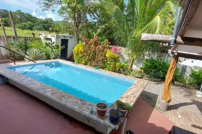a swimming pool in a backyard with plants and trees at Beach House with a Pool-2mn walk to the beach in Playa Guacalillo