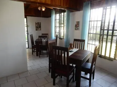 a dining room with a table and chairs and windows at Beach House with a Pool-2mn walk to the beach in Playa Guacalillo