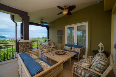 a living room with a table and chairs on a balcony at Vista Bahia 3C 3 bdr Ocean View in Los Suenos in Herradura
