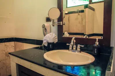 a bathroom with a sink and a mirror at Café de Playa Beach Front Hotel in Coco