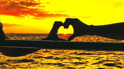 two people in a boat on the ocean with a sunset at Café de Playa Beach Front Hotel in Coco