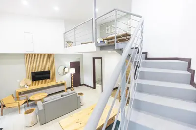 a staircase leading up to a living room with a fireplace at Paradise Bay Hotel Boutique in Herradura