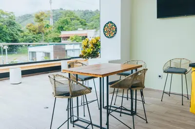 a table and chairs in a room with a balcony at Paradise Bay Hotel Boutique in Herradura