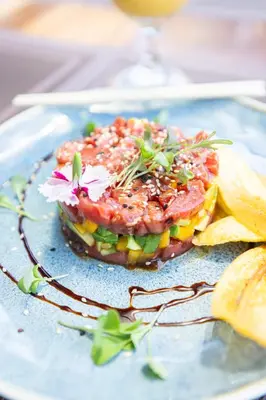 a plate of food with a sandwich with a flower on it at Paradise Bay Hotel Boutique in Herradura
