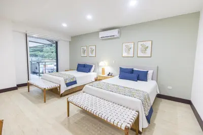 a hotel room with two beds and a window at Paradise Bay Hotel Boutique in Herradura