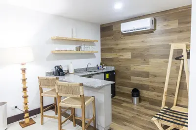 a kitchen with a counter and wooden wall at Paradise Bay Hotel Boutique in Herradura
