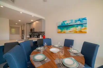 a dining room with a wooden table and blue chairs at Del Mar 1G 3 bdr Ocean View in Los Suenos in Herradura