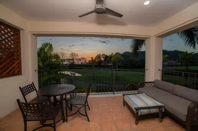a screened in porch with a couch and a table and chairs at Del Mar 1G 3 bdr Ocean View in Los Suenos in Herradura