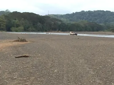 a truck parked on a beach near the water at Cabina equipada cerca de río y montañas Tulín Azul in Tulín