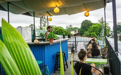 a group of people sitting at a bar on a balcony at Argdivan Hostel in Fortuna