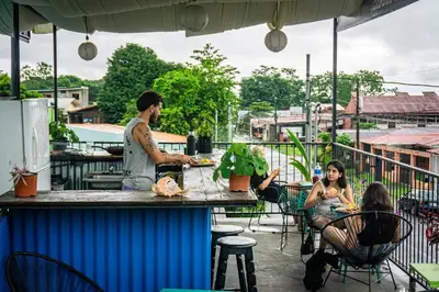 people sitting at a bar on a patio at Argdivan Hostel in Fortuna