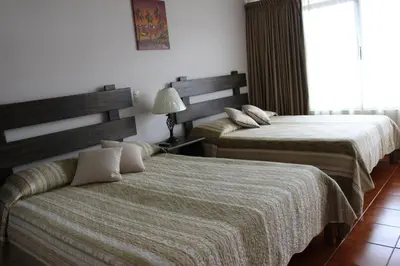 a hotel room with two beds and a window at Hotel Arenal by Regina in Fortuna