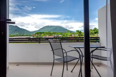 a table and chairs on a balcony with a view of mountains at Hotel Arenal by Regina in Fortuna