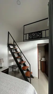 a black staircase in a bedroom with a bed at Hotel Arenal by Regina in Fortuna
