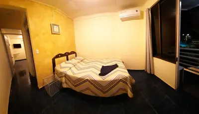 a bedroom with a bed in the corner of a room at Hotel Mirasol in Jacó