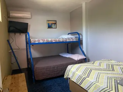 a bedroom with two bunk beds and a television at Hotel Mirasol in Jacó