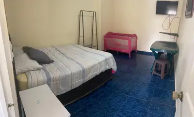 a bedroom with a bed and a pink suitcase at Hotel Mirasol in Jacó