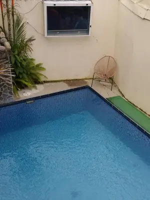 a small blue swimming pool with a chair and a window at Hotel Mirasol in Jacó