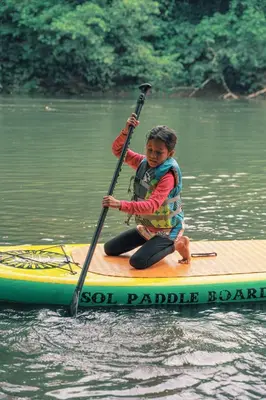 a young boy sitting on a paddle board in the water at Casa Sol in Sarapiquí