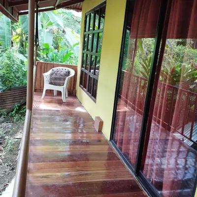 a porch of a house with a chair on it at Casa Sol in Sarapiquí