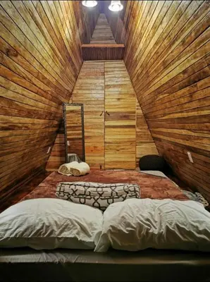 a bedroom with two beds in a room with wooden walls at Airport Traveler's home. in Alajuela City