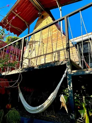 a hammock hanging from the side of a house at Airport Traveler's home. in Alajuela City