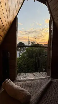 an open door to a balcony with a view of the water at Airport Traveler's home. in Alajuela City
