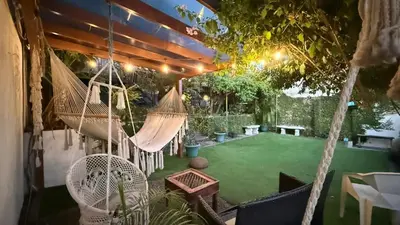 a backyard with a hammock and a green yard at Airport Traveler's home. in Alajuela City
