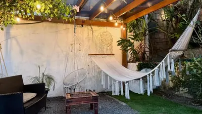a hammock in a garden with a patio at Airport Traveler's home. in Alajuela City