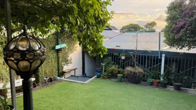 a backyard with a fence and a yard with plants at Airport Traveler's home. in Alajuela City