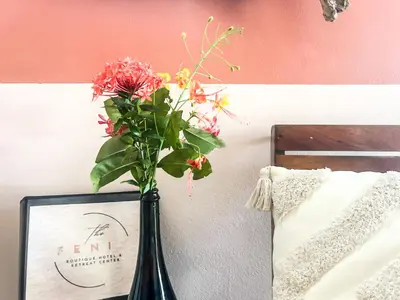 a vase with flowers in it next to a picture at Fenix Hotel - On the Beach in Sámara