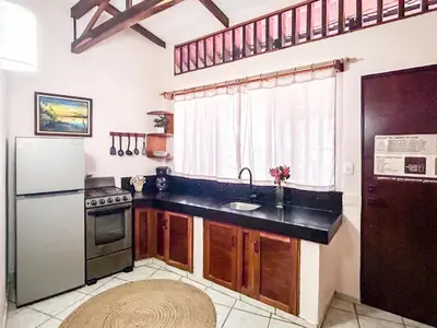 a kitchen with a sink and a refrigerator at Fenix Hotel - On the Beach in Sámara