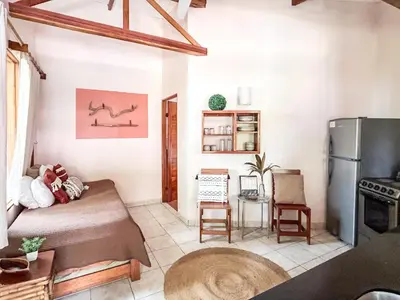 a living room with a bed and a refrigerator at Fenix Hotel - On the Beach in Sámara