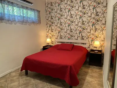 a bedroom with a red bed with a red blanket at Casa Maiana in Sámara