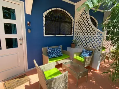 a patio with wicker chairs and a table at Casa Maiana in Sámara