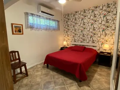 a bedroom with a red bed with a red blanket at Casa Maiana in Sámara