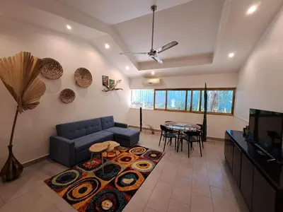 a living room with a blue couch and a table at Casa Mapache in Tamarindo