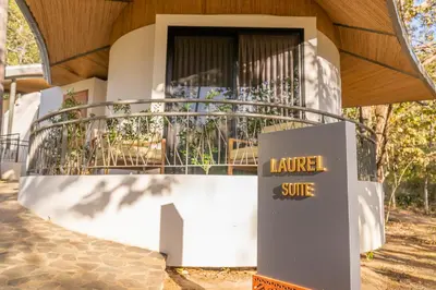 a sign in front of a building with a balcony at Suitree Experience Hotel in Guanacaste