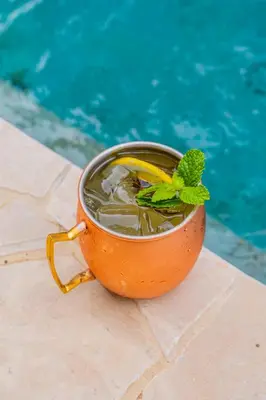 a cup of tea next to a swimming pool at Suitree Experience Hotel in Guanacaste
