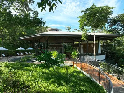 a building with a fence in front of a yard at Suitree Experience Hotel in Guanacaste