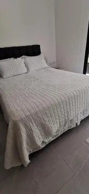 a bedroom with a bed with a white comforter at Hakuna in San Juanillo